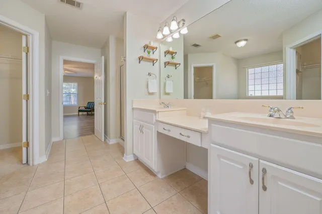 a bedroom with a large bed and a chandelier fan