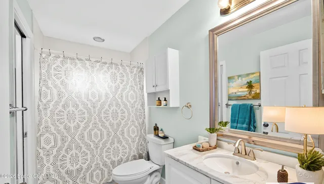 a view of a street with flower plants and wooden fence