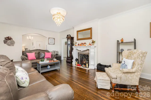 a living room with furniture a chandelier and a flat screen tv