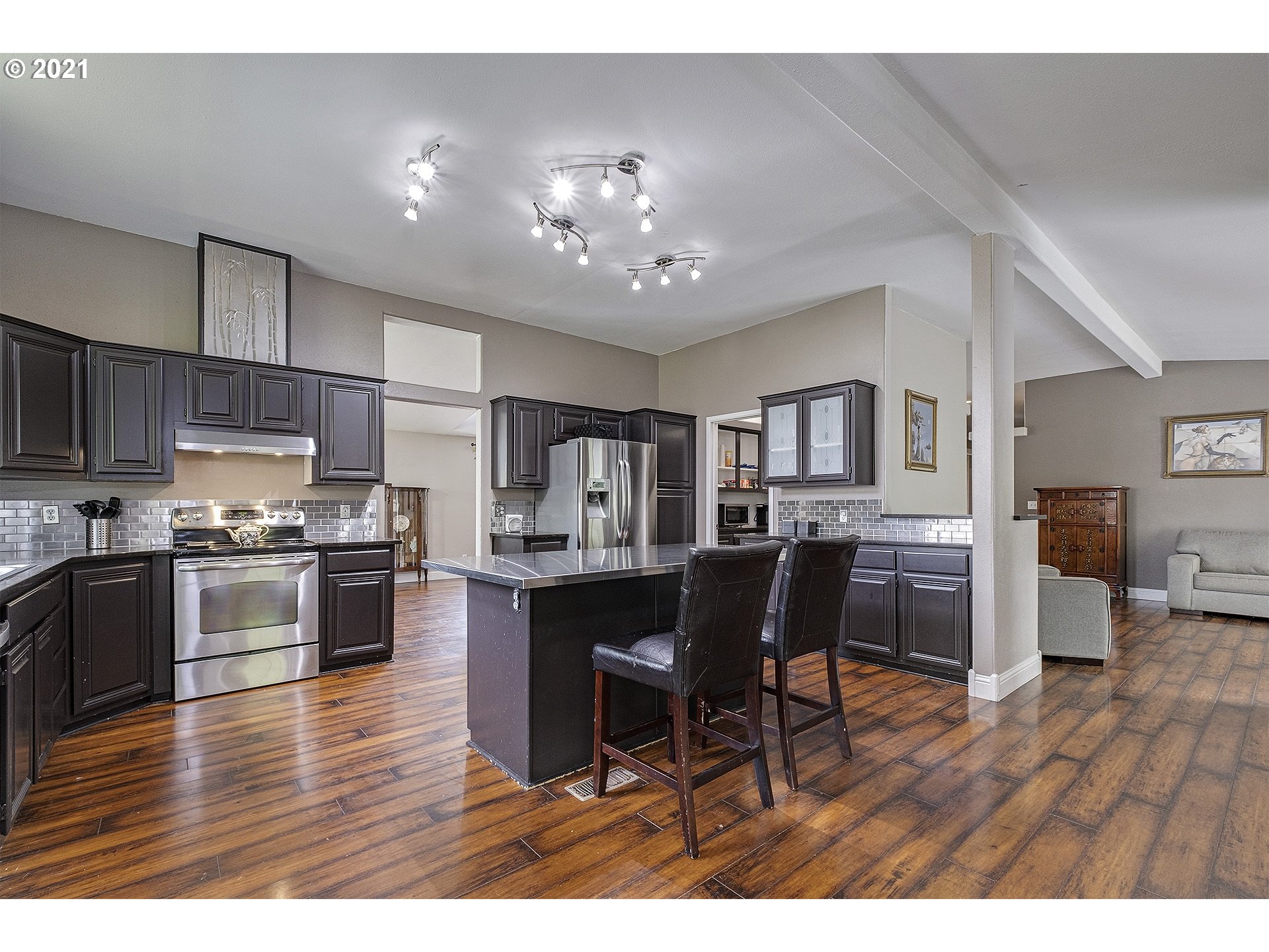 4300 Mapleton Drive West Linn, OR 97068 - Photo 11 of 32 a open kitchen with stainless steel appliances kitchen island granite countertop a table chairs and a refrigerator