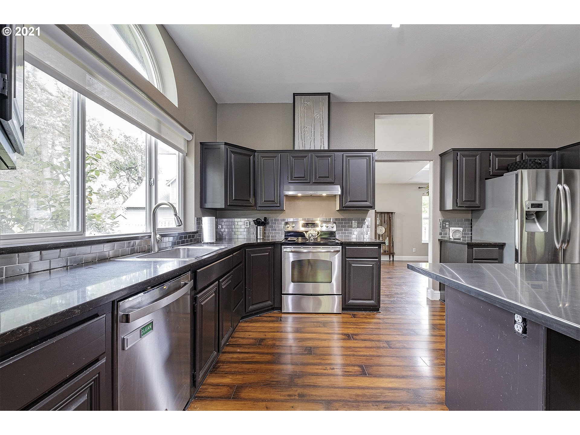 4300 Mapleton Drive West Linn, OR 97068 - Photo 12 of 32 a kitchen with kitchen island granite countertop a sink appliances cabinets and a large window