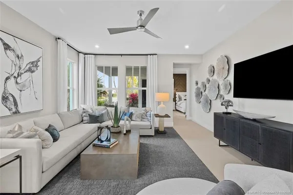 a living room with furniture a flat screen tv and white walls