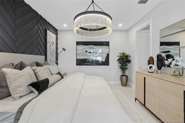 a bedroom with bed and a painting on the wall