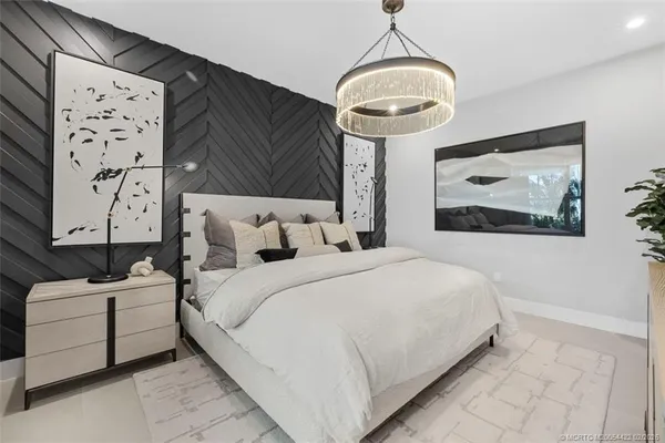 a bedroom with a large bed and a chandelier