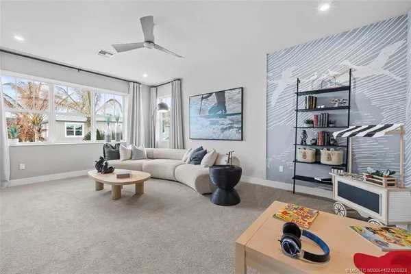 a living room with furniture a flat screen tv and a large window