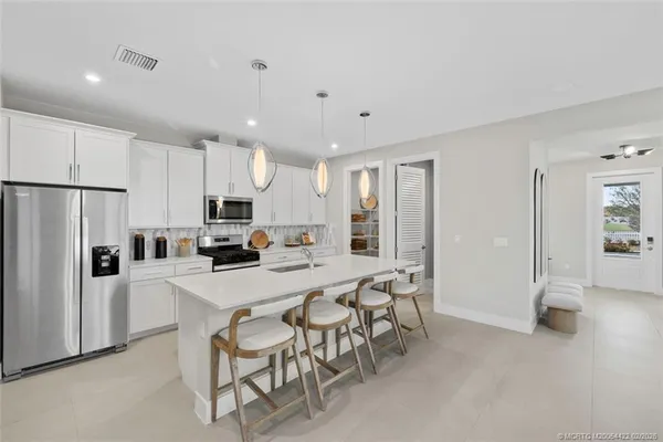 a large white kitchen with cabinets