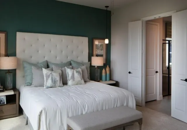 a bedroom with a large bed and a chandelier