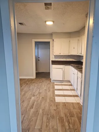a view of a kitchen with wooden floor and electronic appliances