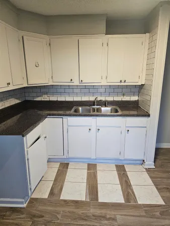 a kitchen with granite countertop white cabinets and white appliances
