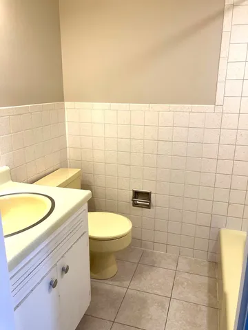 a bathroom with a granite countertop toilet and a sink