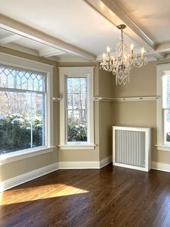a view of a livingroom with wooden floor and a large window