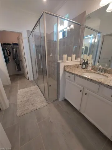 a bathroom with a granite countertop sink a mirror and a shower