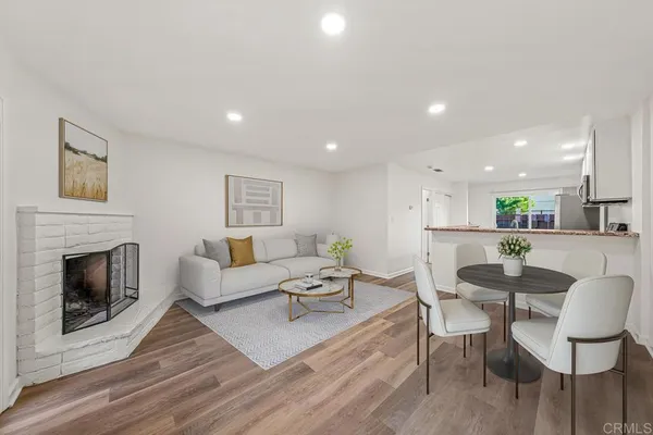 a living room with furniture a fireplace and a kitchen view