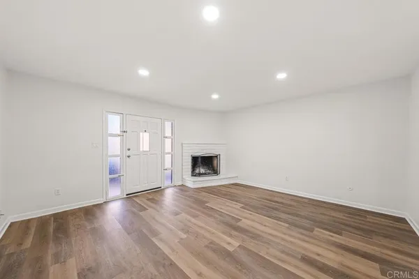 a view of an empty room with a fireplace and a window