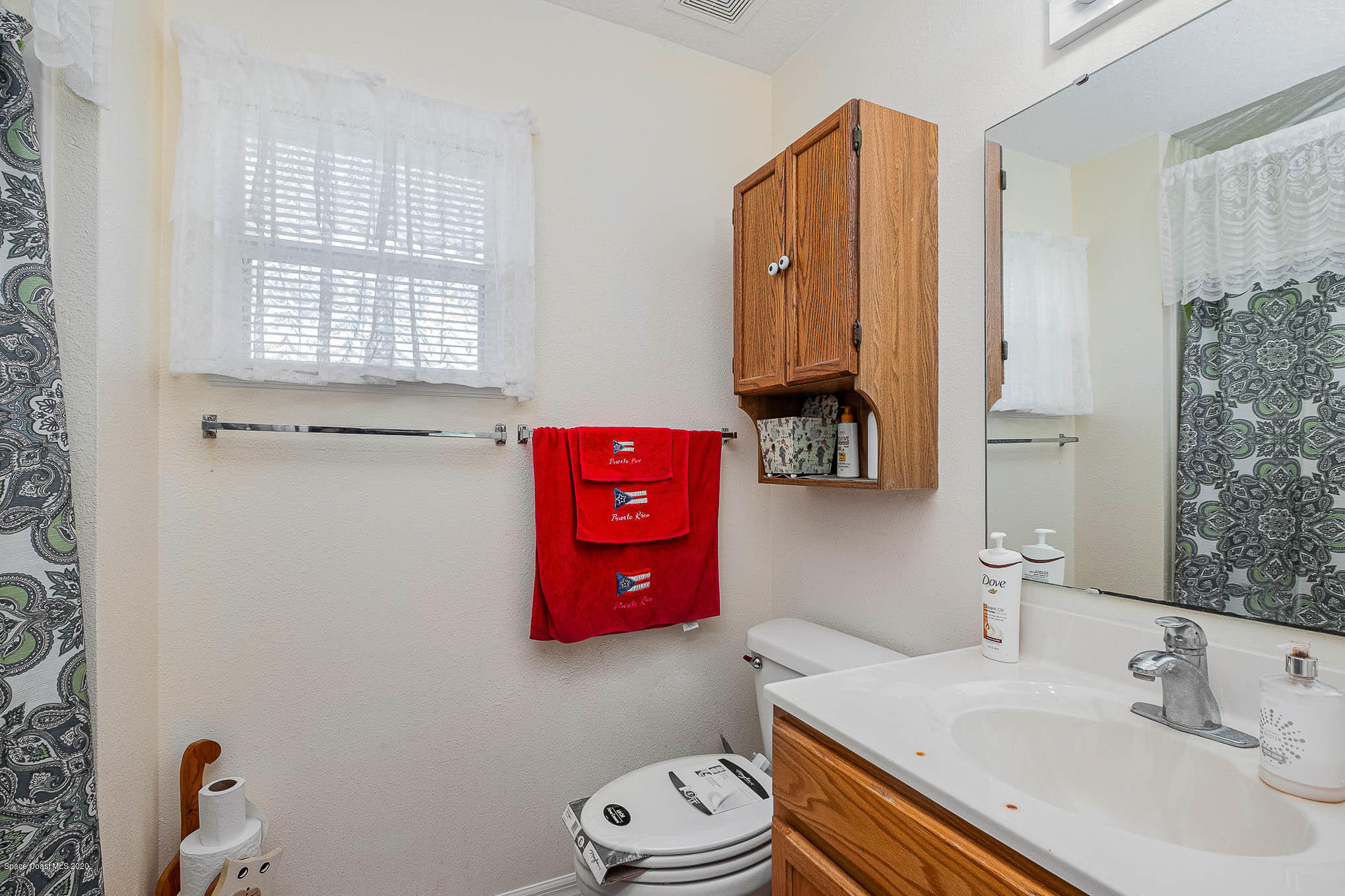 498 Scarlet Road Southwest Palm Bay, FL 32908 - Photo 23 of 24 a bathroom with a sink toilet vanity and window