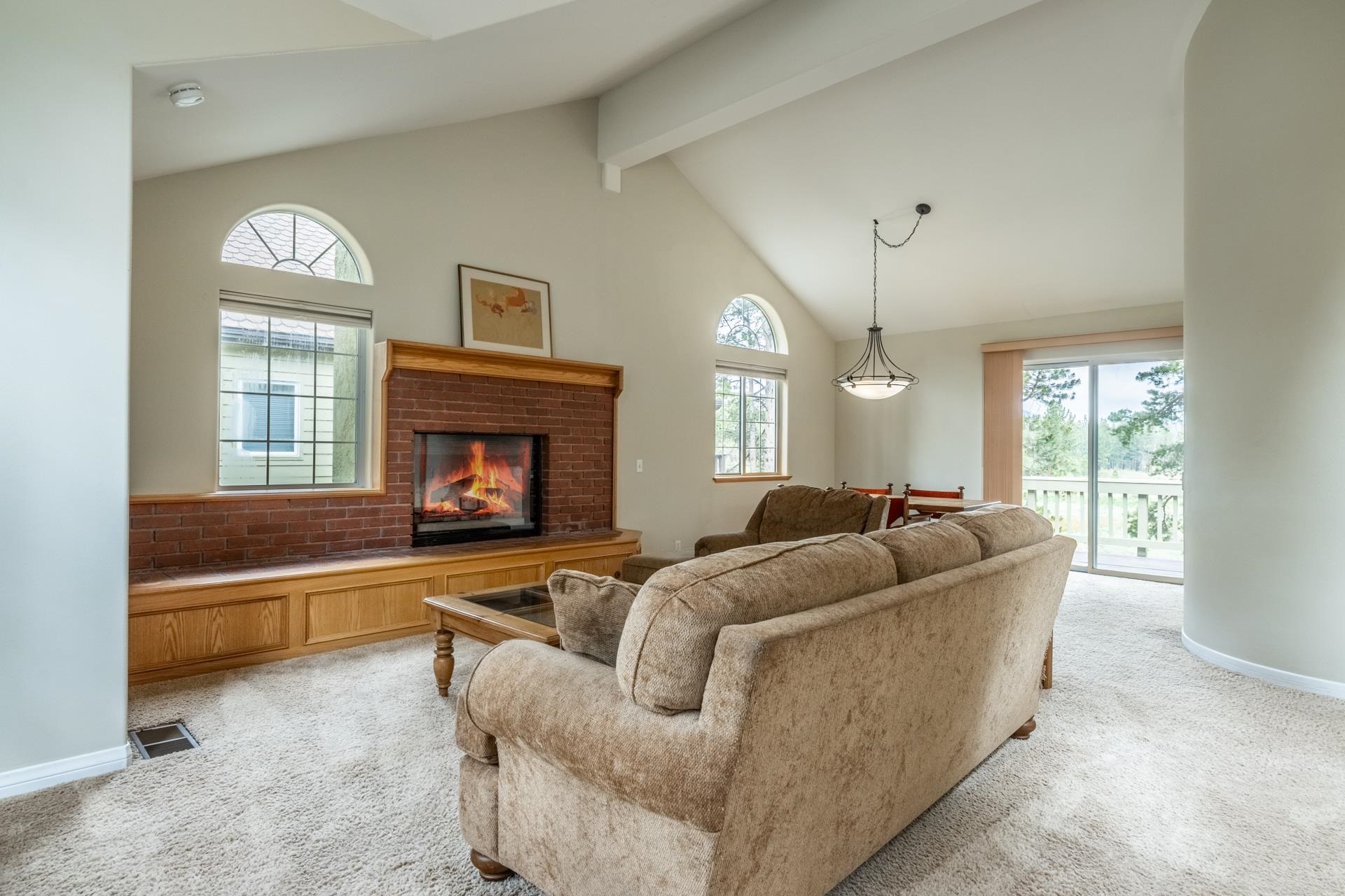 272 Ridge Way Mammoth Lakes, CA 93546 - Photo 12 of 55 Spacious living area featuring a vaulted ceiling, brick fireplace with wood mantel, and built-in wood bench seating
