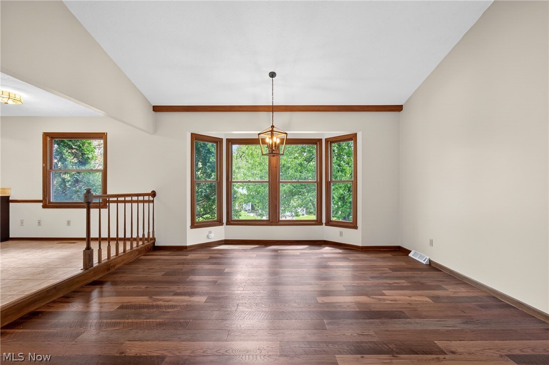 5346 Burlawn Street Northwest Canton, OH 44708 - Photo 8 of 40 Expansive room featuring wood-finish flooring, a bay window with natural wood trim, a decorative ceiling beam.