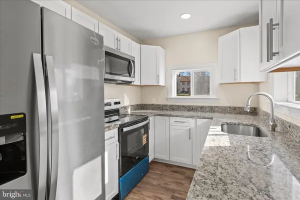 a kitchen with stainless steel appliances granite countertop a refrigerator sink and stove