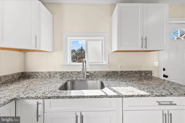 a view of empty room with wooden floor and stairs