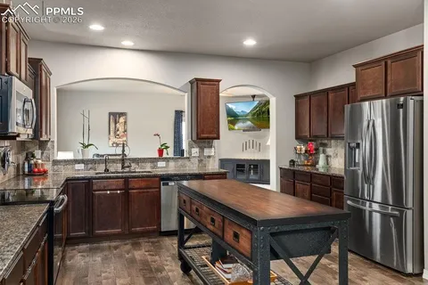 a kitchen with a stove a refrigerator and a sink