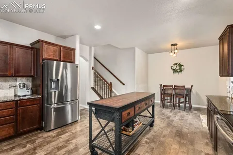 a kitchen with stainless steel appliances granite countertop a refrigerator and a stove top oven