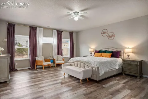 a bedroom with a bed and large windows