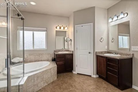 a spacious bathroom with a granite countertop tub sink shower and mirror