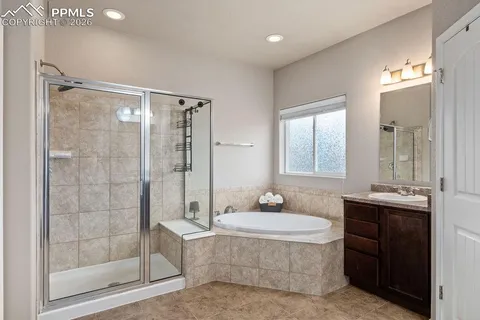 a bathroom with a tub shower sink and mirror
