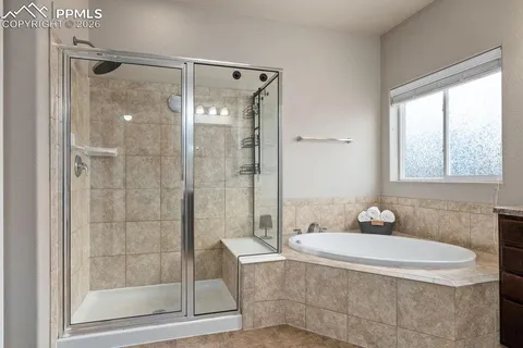 a bathroom with a granite countertop shower a mirror and a sink