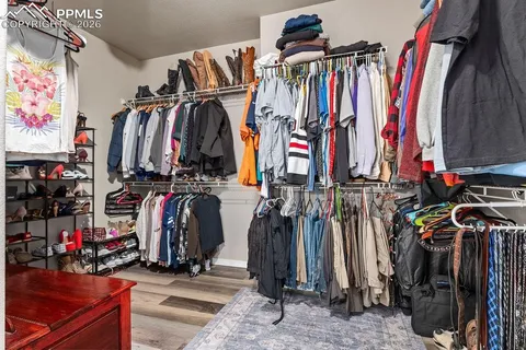 a view of walk in closet with clothes