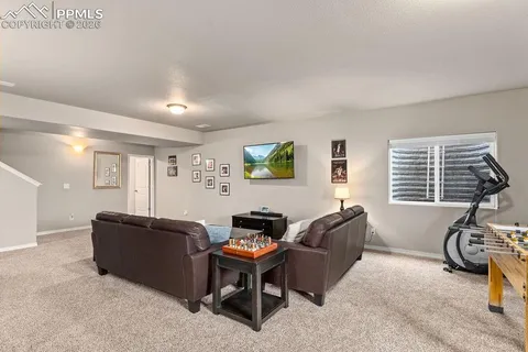 a living room with furniture a window and gym equipment