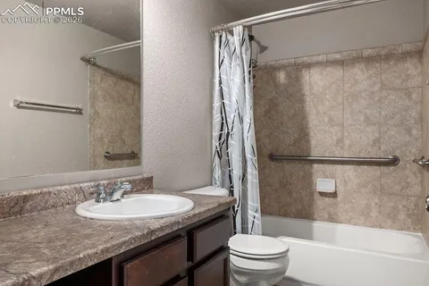 a bathroom with a granite countertop sink toilet and shower