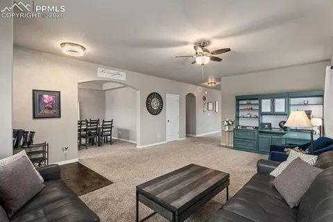 a living room with furniture a clock and a flat screen tv