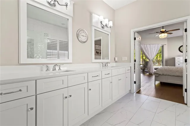 a spacious en suite bathroom with double sink and a large mirror
