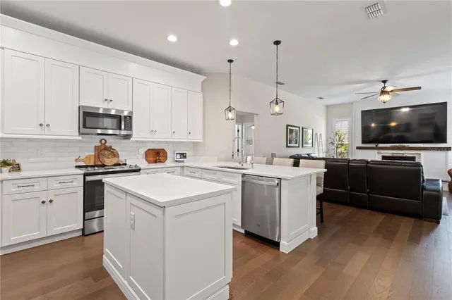 a kitchen with a sink stainless steel appliances and white cabinets