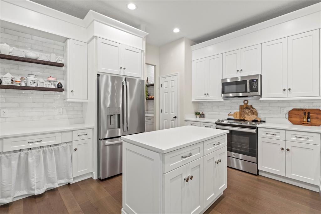 11208 Ledgement Lane Windermere, FL 34786 - Photo 17 of 36 a kitchen with white cabinets and stainless steel appliances