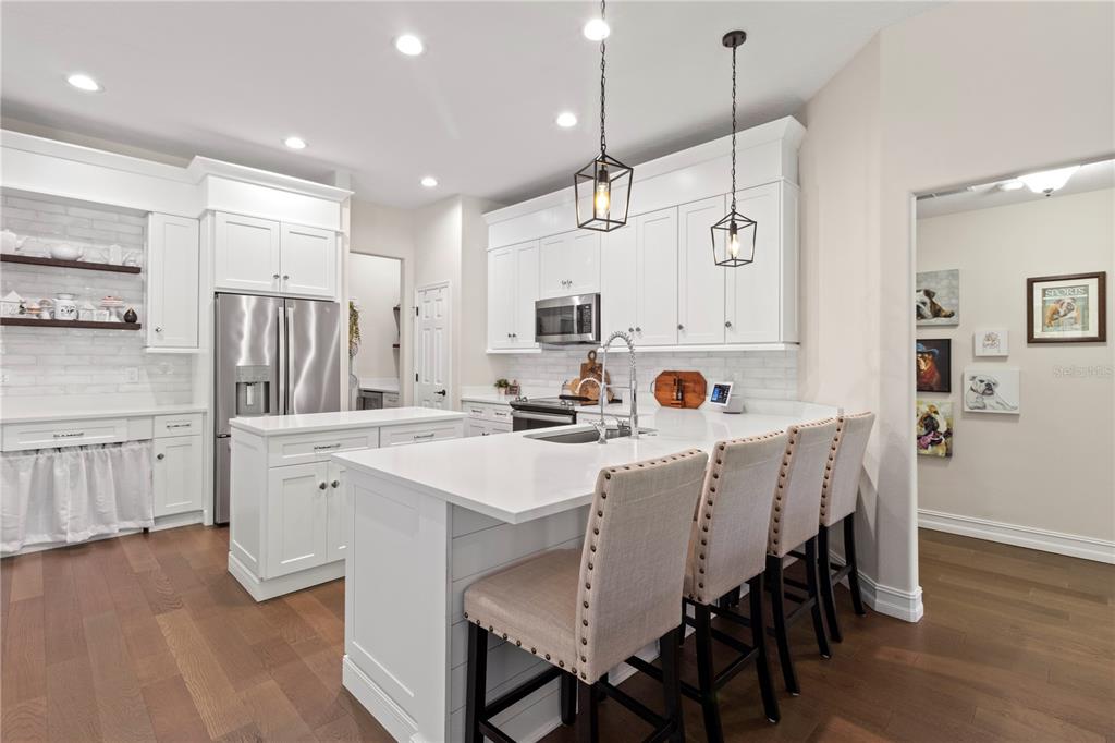 11208 Ledgement Lane Windermere, FL 34786 - Photo 18 of 36 a kitchen with a dining table chairs refrigerator and cabinets