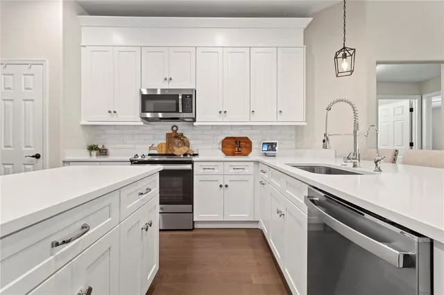 a kitchen with white cabinets and white appliances