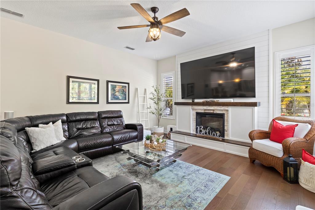11208 Ledgement Lane Windermere, FL 34786 - Photo 21 of 36 a living room with furniture a flat screen tv and a fireplace