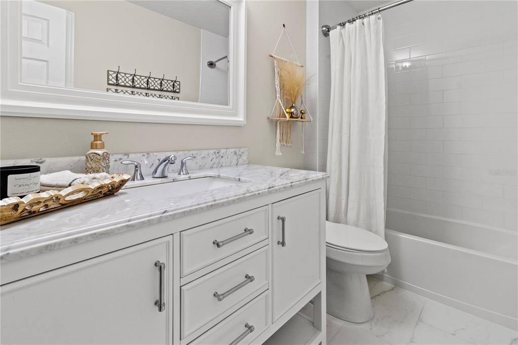 11208 Ledgement Lane Windermere, FL 34786 - Photo 24 of 36 a bathroom with a granite countertop sink a toilet and a bathtub