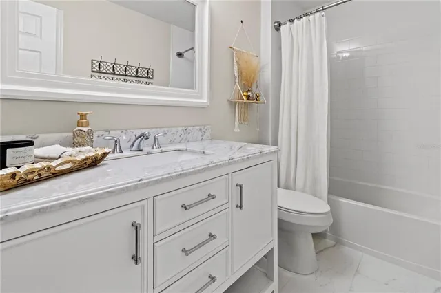 a bathroom with a granite countertop sink a toilet and a bathtub