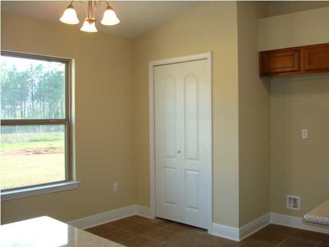 5608 Price Plantation Road Baker, FL 32531 - Photo 10 of 34 a view of an empty room with wooden floor and windows