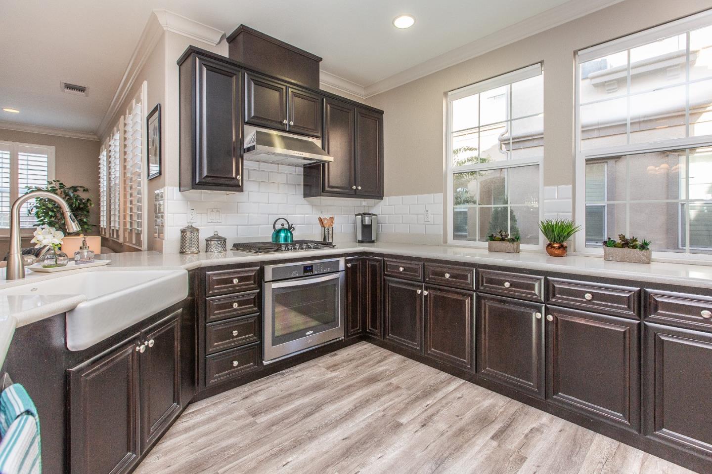 104 Caspian Way Gilroy, CA 95020 - Photo 11 of 33 a kitchen with stainless steel appliances granite countertop a sink stove and wooden cabinets