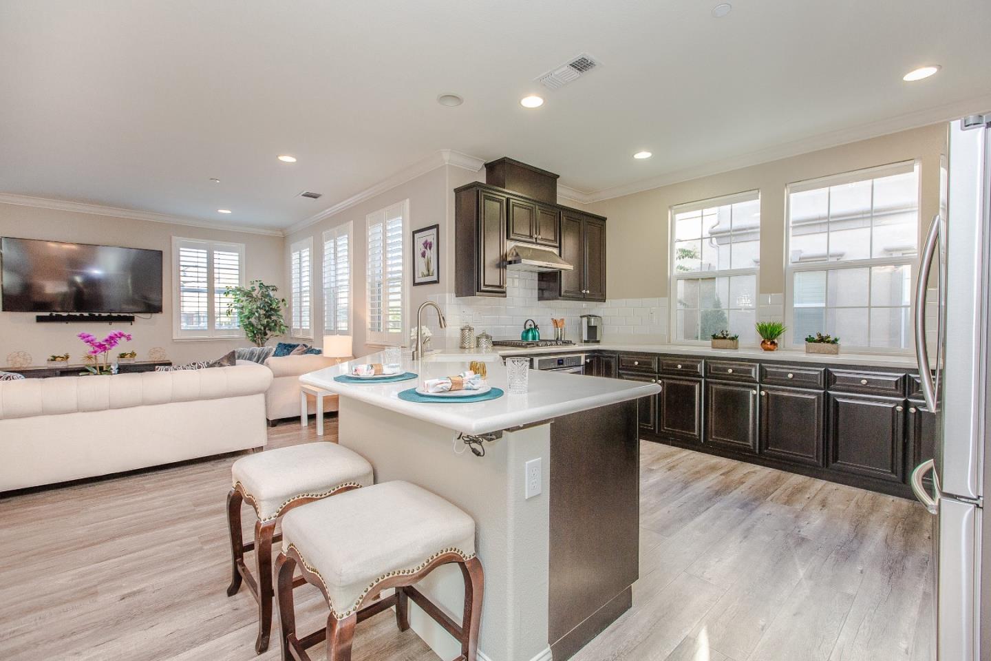 104 Caspian Way Gilroy, CA 95020 - Photo 10 of 33 a kitchen with stainless steel appliances kitchen island granite countertop a sink and a stove top oven with wooden floor