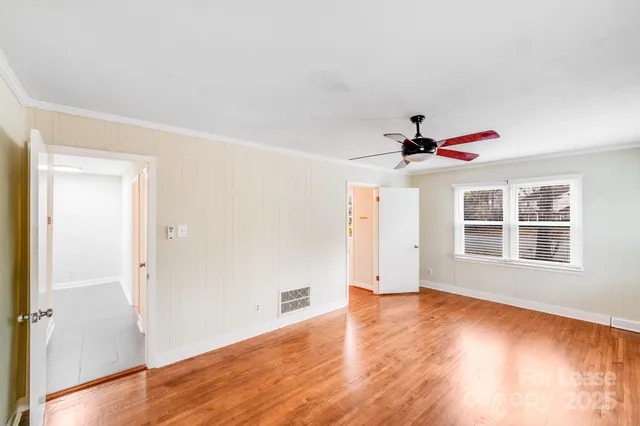 a view of a room with wooden floor and ceiling fan