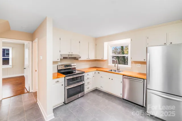 a kitchen with granite countertop stainless steel appliances and refrigerator