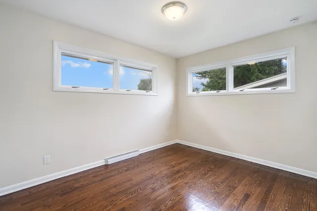 a view of a small space with wooden floor and a window