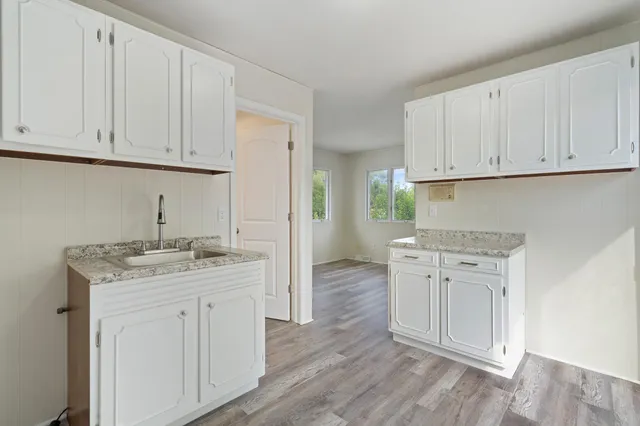 a kitchen with stainless steel appliances granite countertop a sink stove and cabinets