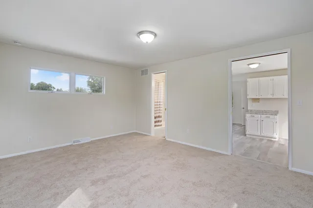 an empty room with closet and windows