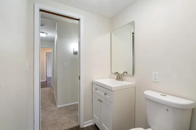 a bathroom with a sink toilet and mirror